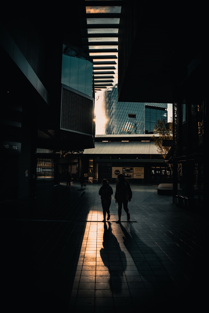 a couple people walking down a sidewalk