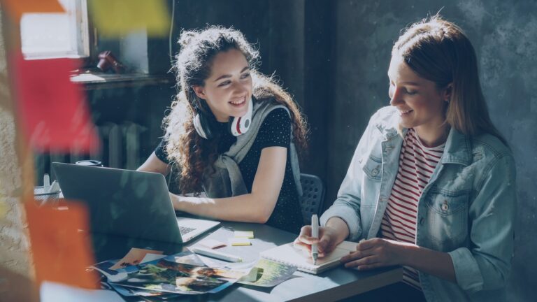 Two women collaborate on a project.